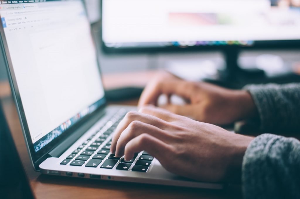 Cette image représente les mains d'un homme entrain de taper sur un clavier pour créer un site wordpress.